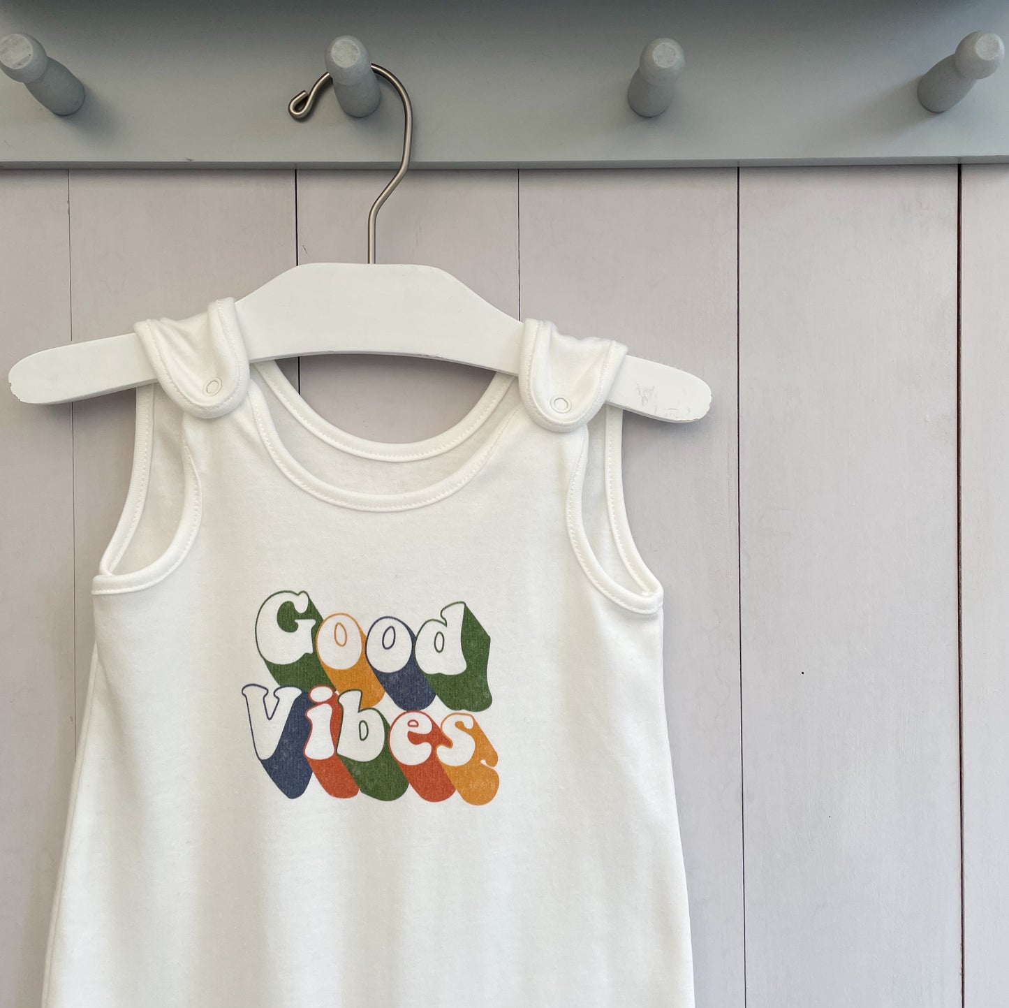 milk white baby romper with retro inspired quote 'good vibes'. super soft 100% organic baby clothing. perfect for new born baby gift