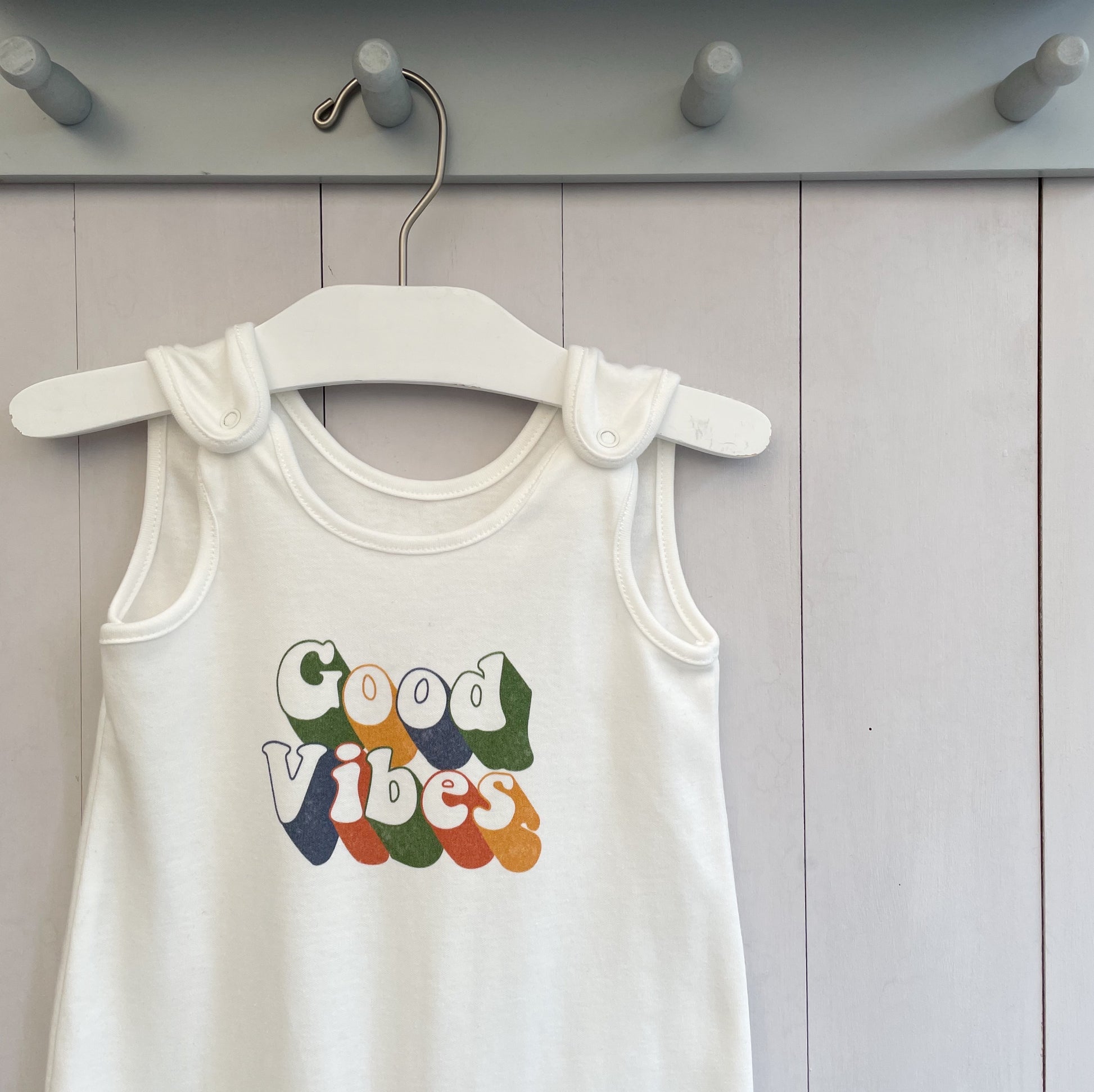milk white baby romper with retro inspired quote 'good vibes'. super soft 100% organic baby clothing. perfect for new born baby gift 